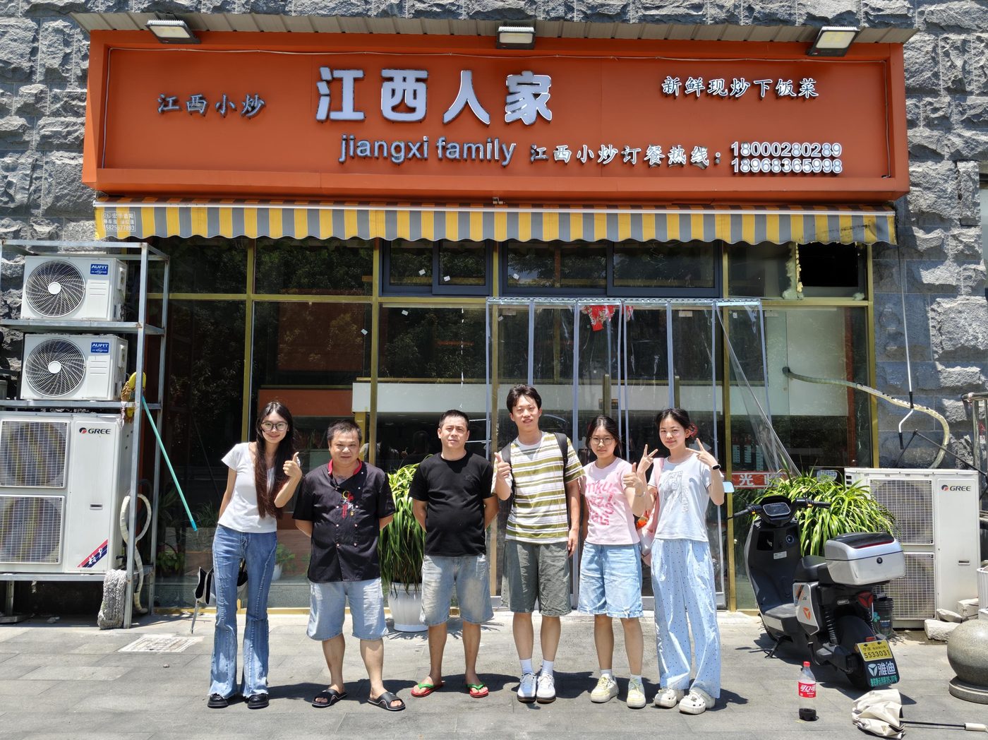 伍进制全队与江西人家老板在店门口合影